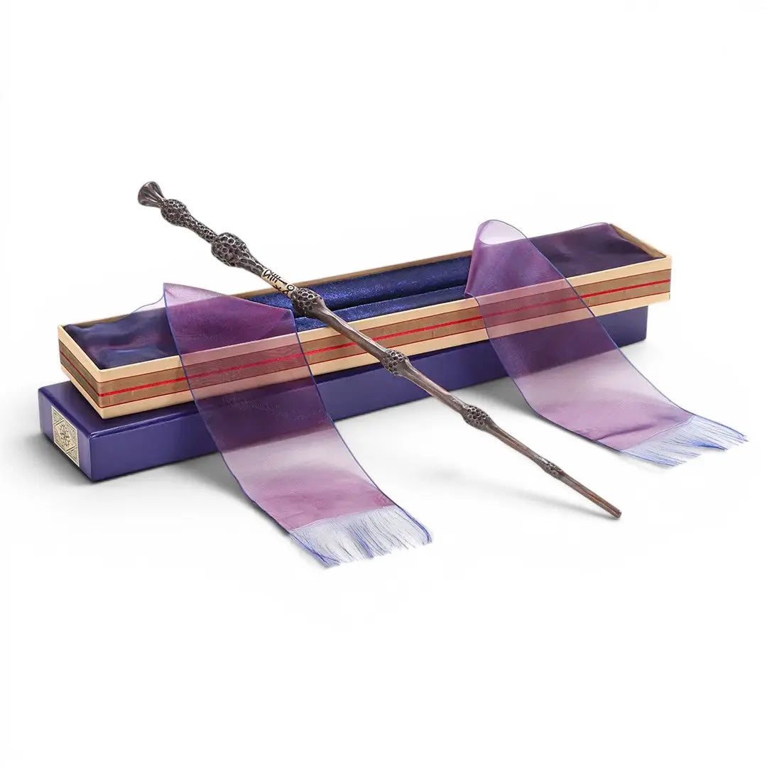 La boutique Aux 2 Balais - Réplique de la Baguette de Sureau Dumbledore en résine, 40 cm, dans sa boîte Ollivander avec ruban violet.