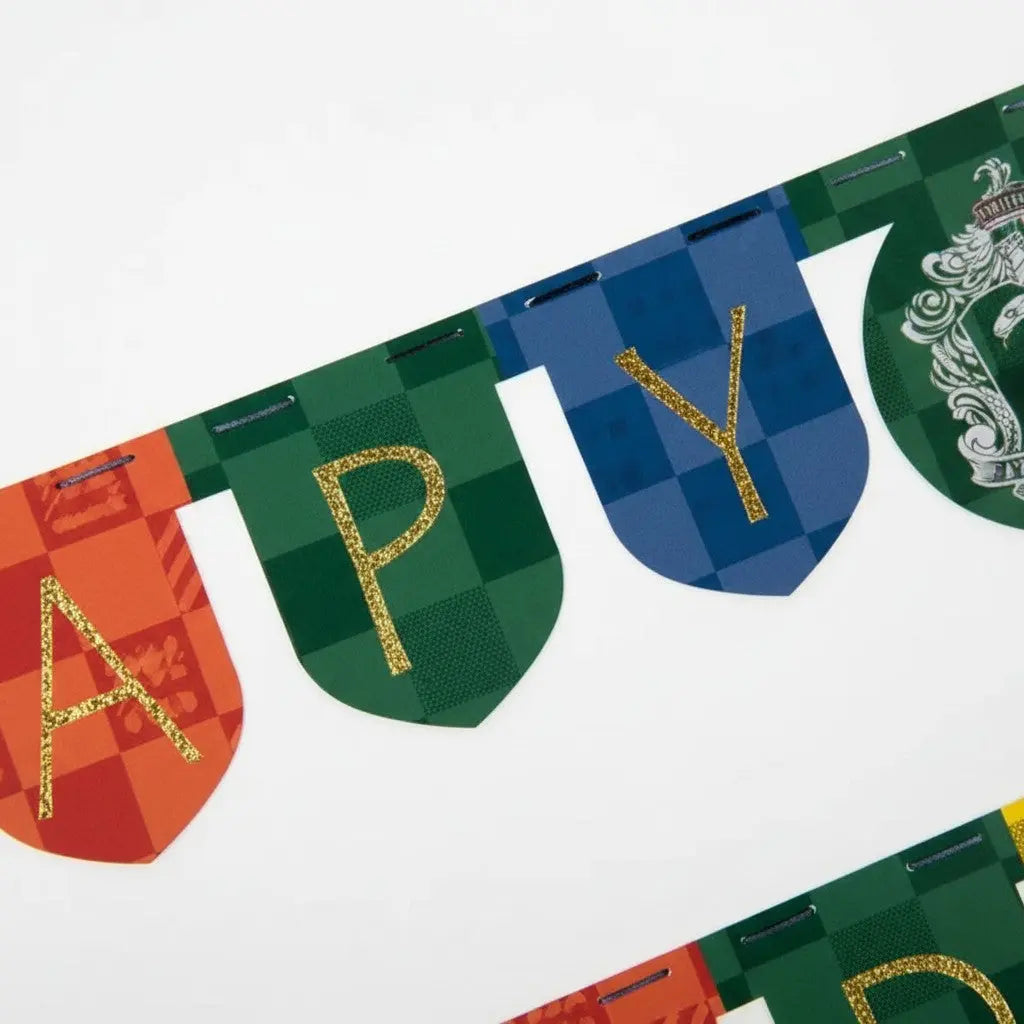Guirlande fanions "Happy Birthday" Harry Potter en carton, 2m, aux couleurs des 4 maisons de Poudlard.
