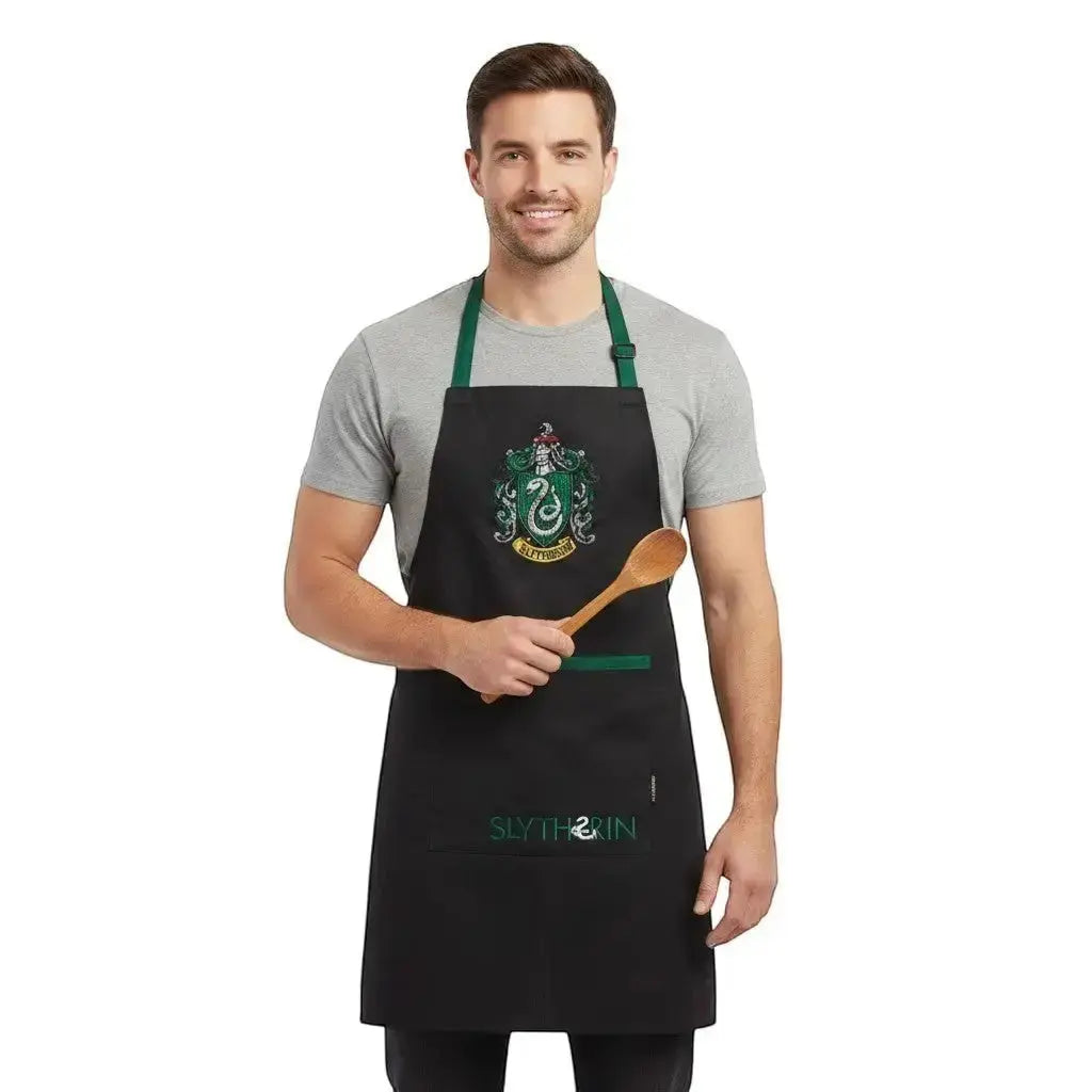 Tablier noir Serpentard Harry Potter en polyester/coton avec écusson et inscription "Slytherin". Taille unique 70x85cm.