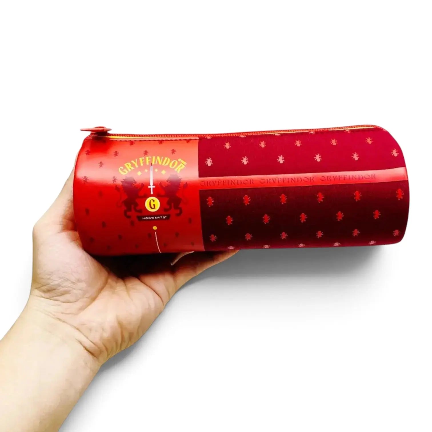Trousse tube Gryffondor en néoprène rouge avec logo officiel, tenue en main, vendue par La boutique Aux 2 Balais